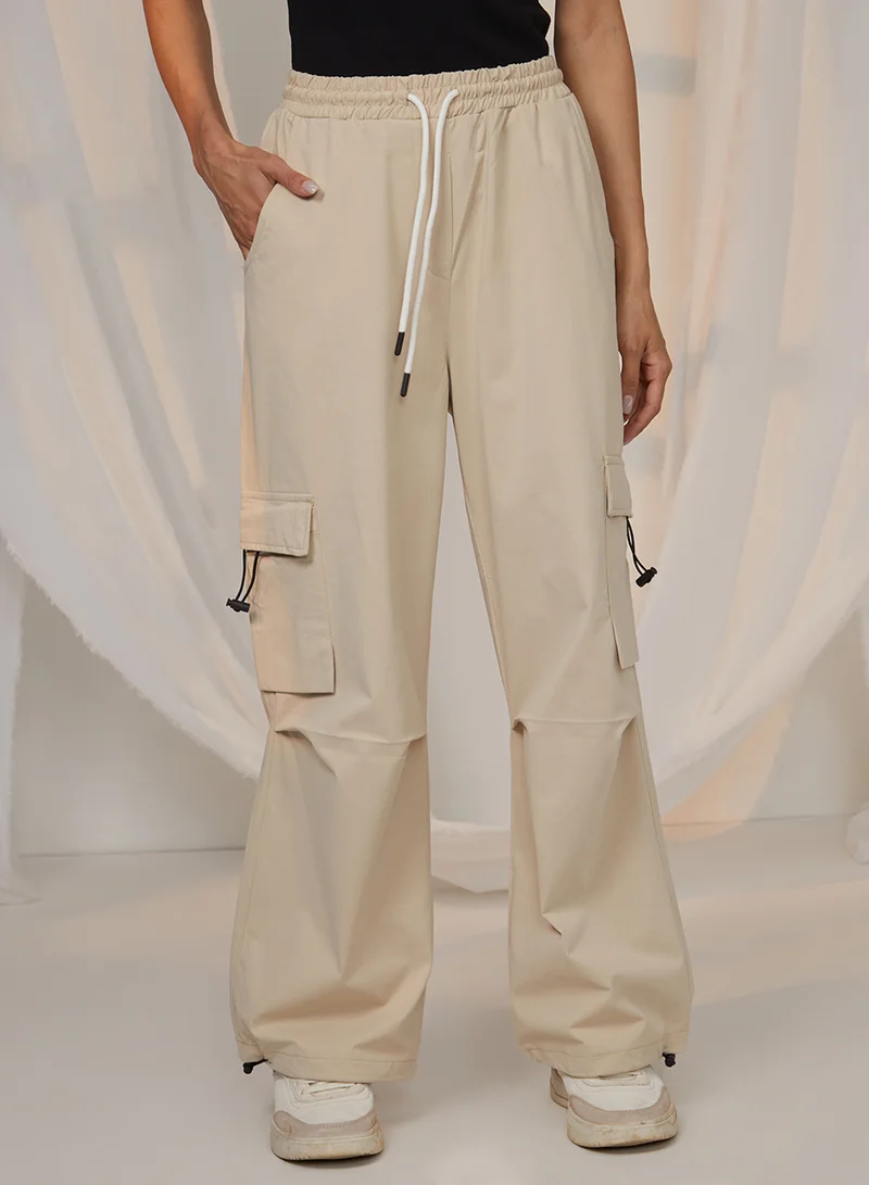 بينيا كولادا Women's Beige Solid Cargo Parachute Trousers For Casual Wear | Mid-Rise | 4 Pockets | Drawstring Closure | Cargo Pants Designed With Comfortable Fit For Woman & Girls